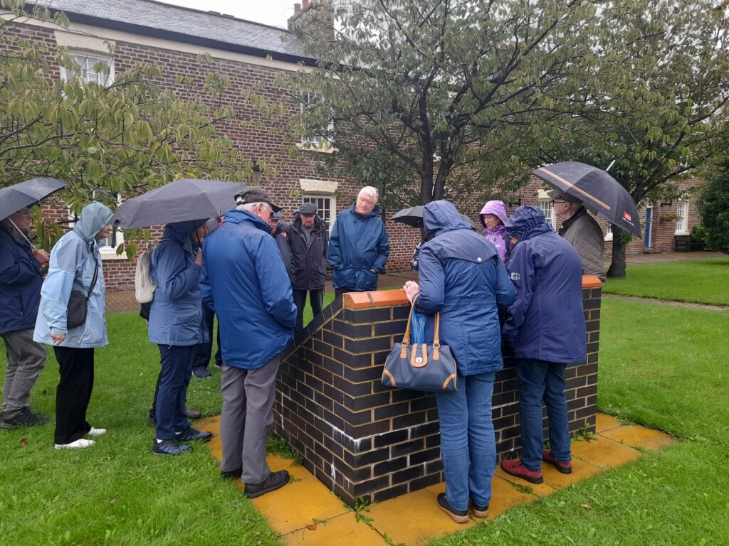 Strollers looking at information board in the rain